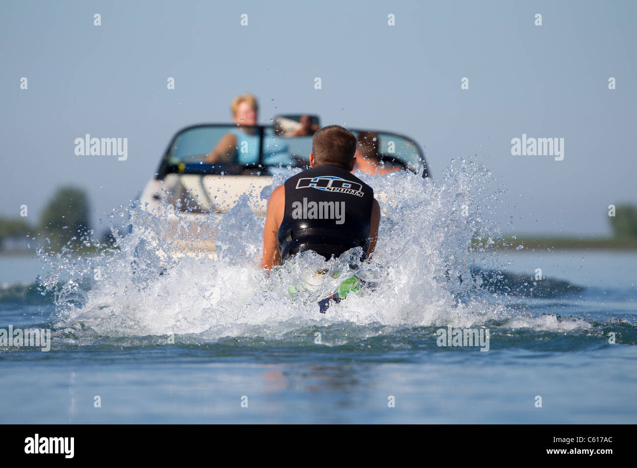 Ein Wasserschifahrer beginnen, aus dem Wasser gezogen zu bekommen, als er seinen Lauf beginnt. Stockfoto