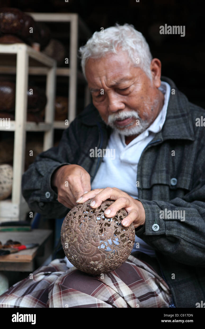 Handwerker, schnitzen eine getrocknete Kokosnuss-Schale. Tampaksiring, Bali, Indonesien, Südostasien, Asien Stockfoto