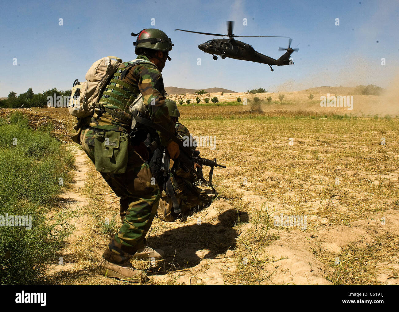 Ein afghanischer Commando klammern sich als UH-60 Black Hawk Hubschrauber kommt, ihn nach einem Clearing Betrieb in Khakrez Bezirk extrahieren, Provinz Kandahar, Afghanistan, 31. Mai 2011. Die Operation führte in den Ausbau von vier mutmaßliche Aufständische, sowie die Ausbeutung des IED - Materialien für die Papierherstellung und eine Waffen - Sichtung Gerät. Der Commando ist zu 3. der afghanischen nationalen Armee Commando Kandak zugeordnet. (U.S. Armee Foto von Sgt. Daniel S. schüttelte/Freigegeben) Stockfoto