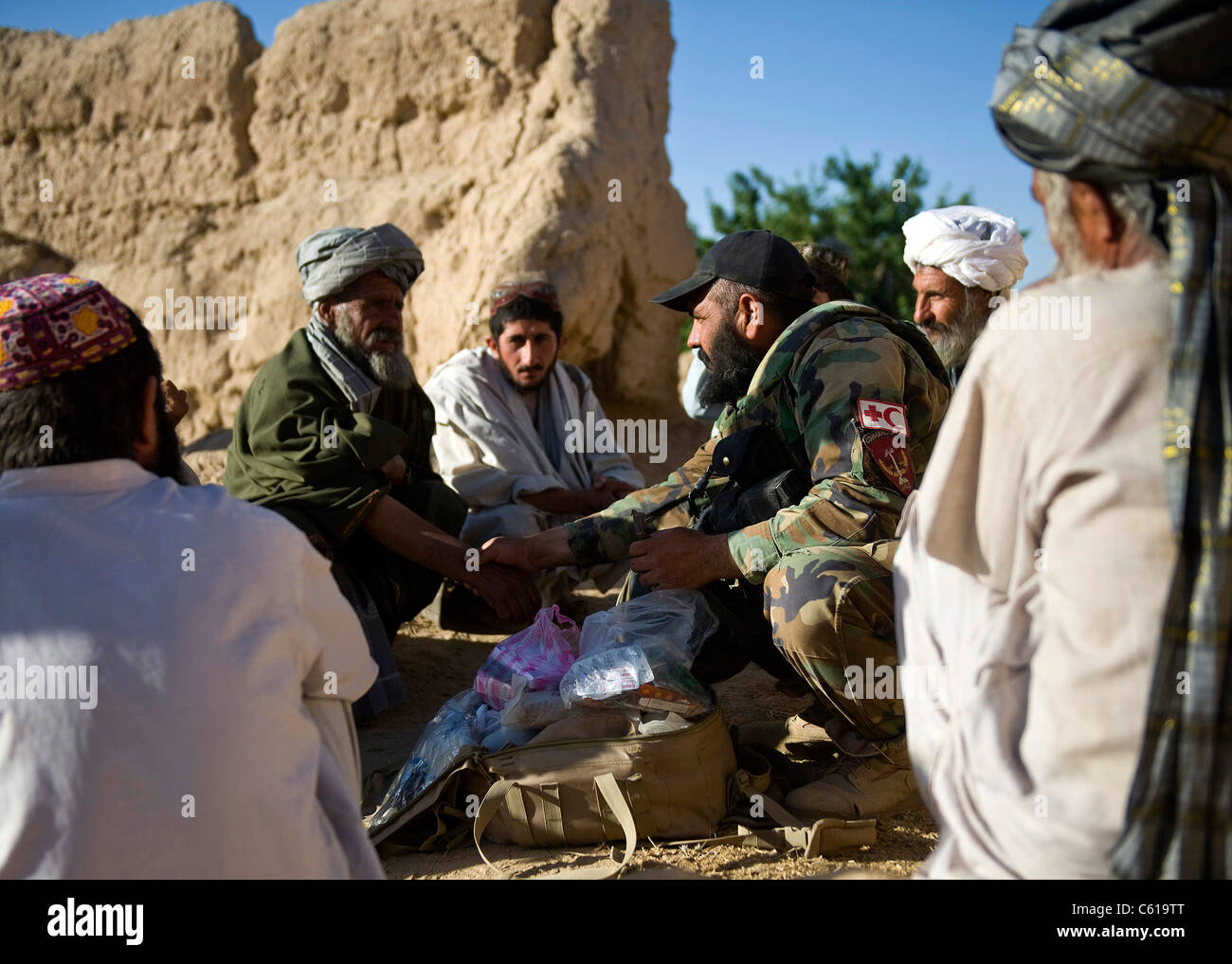 Ein afghanischer Kommandomediziner, unterstützt von den US-Armee-Spezialeinheiten und den Navy-Robben mit Special Operations Task Force-South, bewertet die Herzfrequenz eines kranken Dorfbewohners während einer Clearing-Operation im Bezirk Khakrez, Provinz Kandahar, Afghanistan, 31. Mai 2011. Die Operation führte zur Entfernung von vier mutmaßlichen Aufständischen, sowie zur Ausbeutung von IED-Material und einer Waffenkontrolle. Das Kommando ist mit dem 3. Kommando der afghanischen Nationalarmee Kandak. (USA Armeefoto von Sgt. Daniel P. schüttelte/entließ) Stockfoto