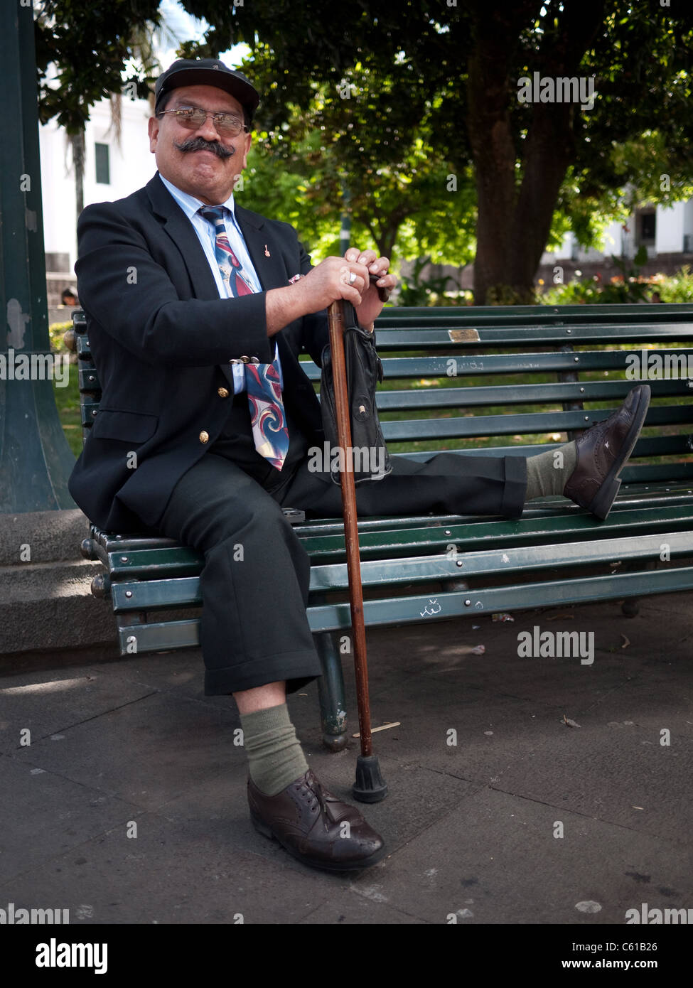 Mann mit Polio sitzt auf einer Parkbank. Stockfoto