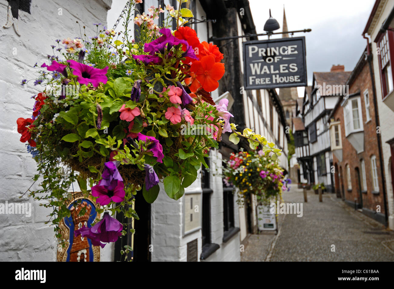 Gepflasterte Straße mit stark hängenden Fachwerkbauten in Ledbury, Herefordshire, England. Stockfoto