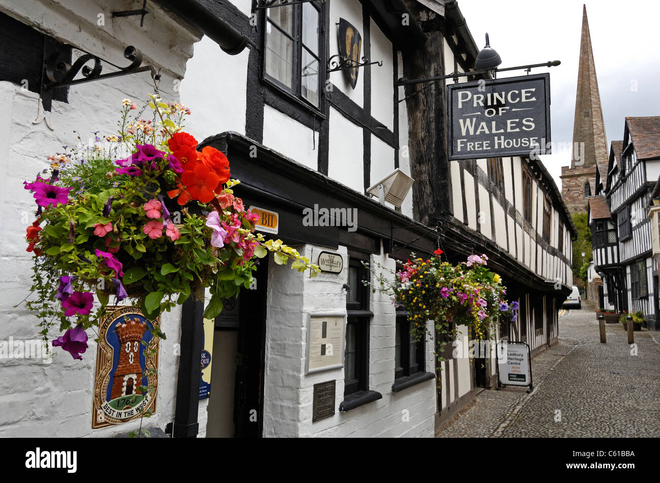 Gepflasterte Straße mit stark hängenden Fachwerkbauten in Ledbury, Herefordshire, England. Stockfoto