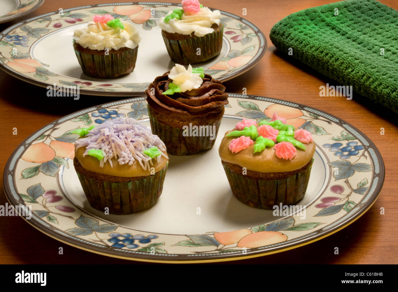 Nahaufnahme der kunstvoll verzierten Cupcakes auf Platten Stockfoto