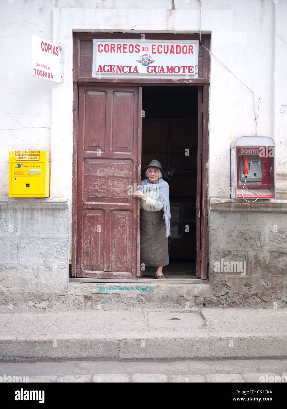 Ältere Frau peering aus einem südamerikanischen Postamt. Stockfoto