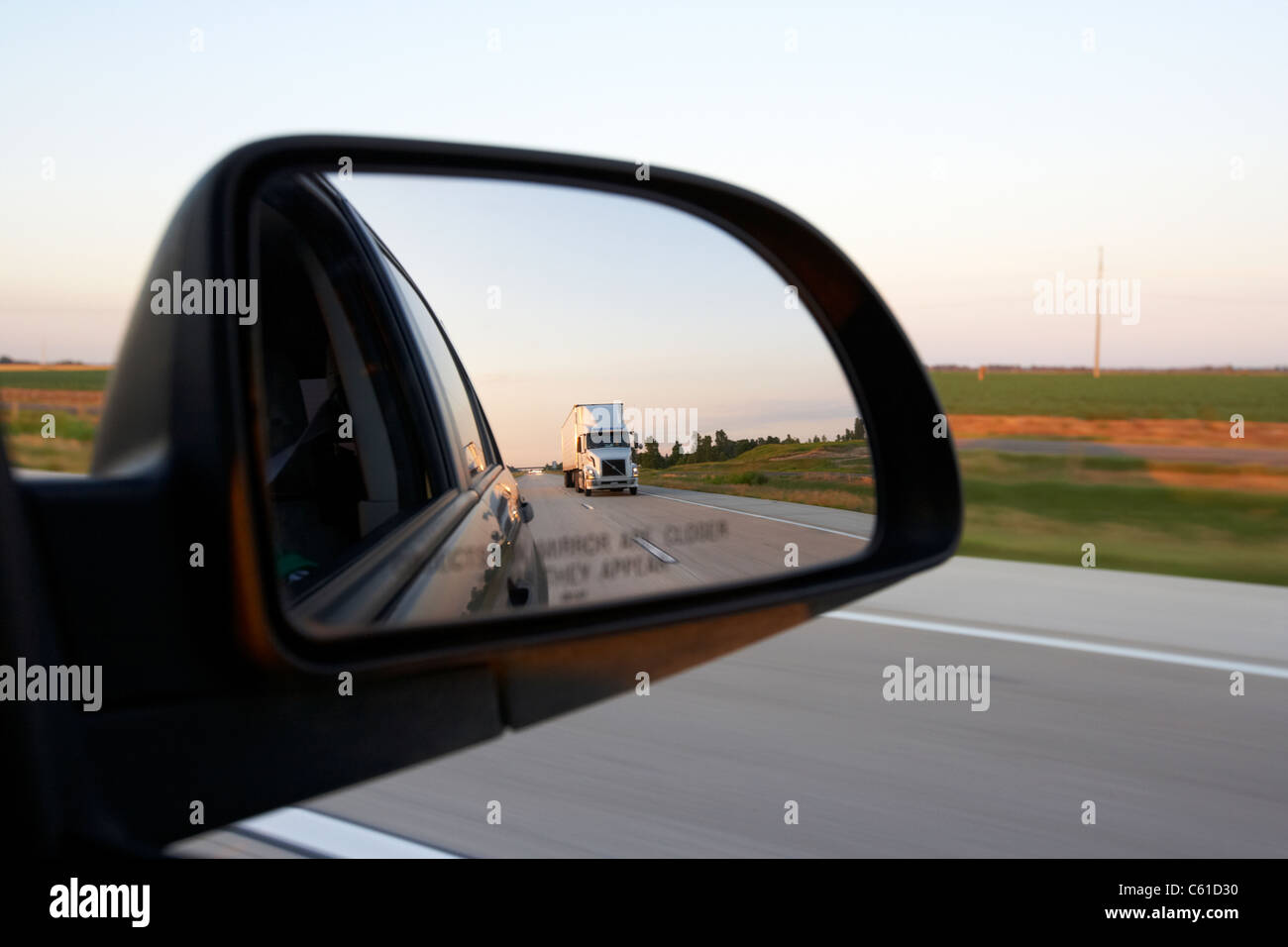 Auto Seite Außenspiegel zeigt hintere Ansicht und halb LKW während der Fahrt entlang einer Autobahn in den usa Stockfoto