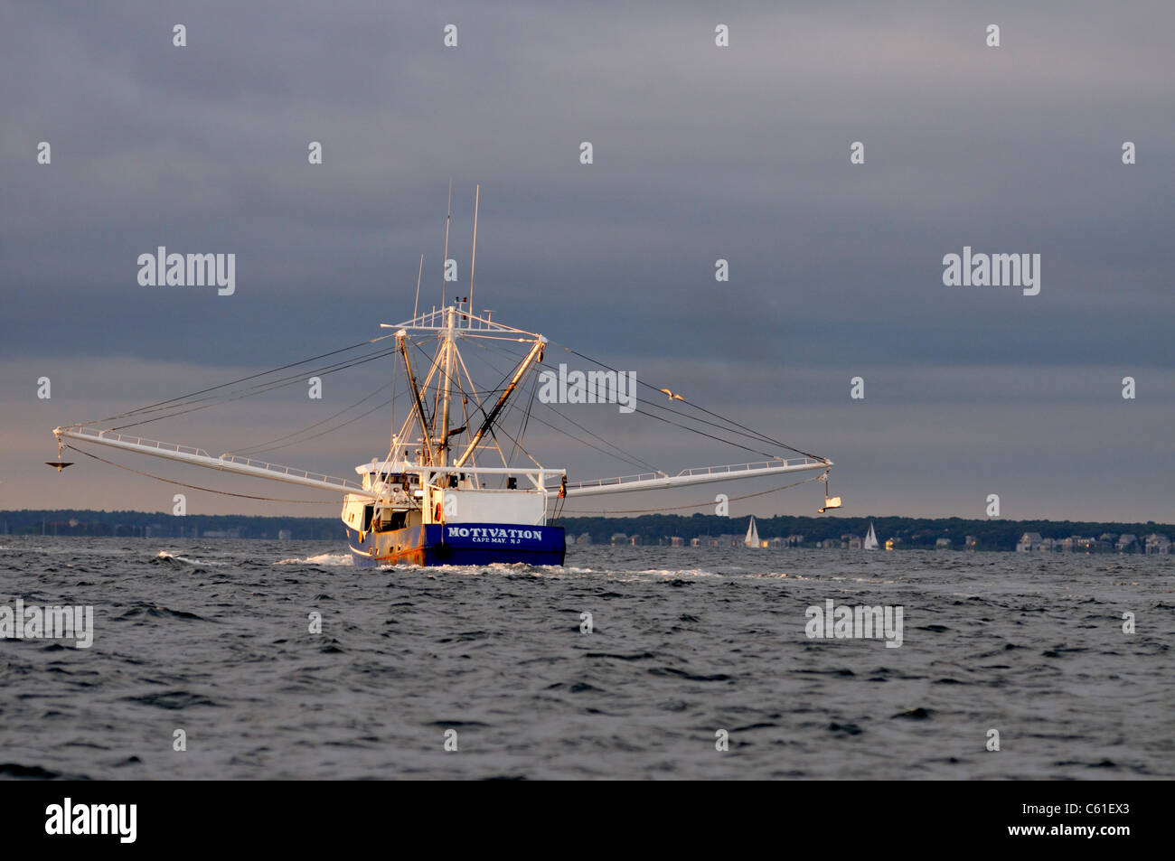 Stern von einem blauen geschälten Fischerboot Fischen vor der Küste von Cape Cod mit Outirggers an einem stürmischen Tag verlängert. USA Stockfoto