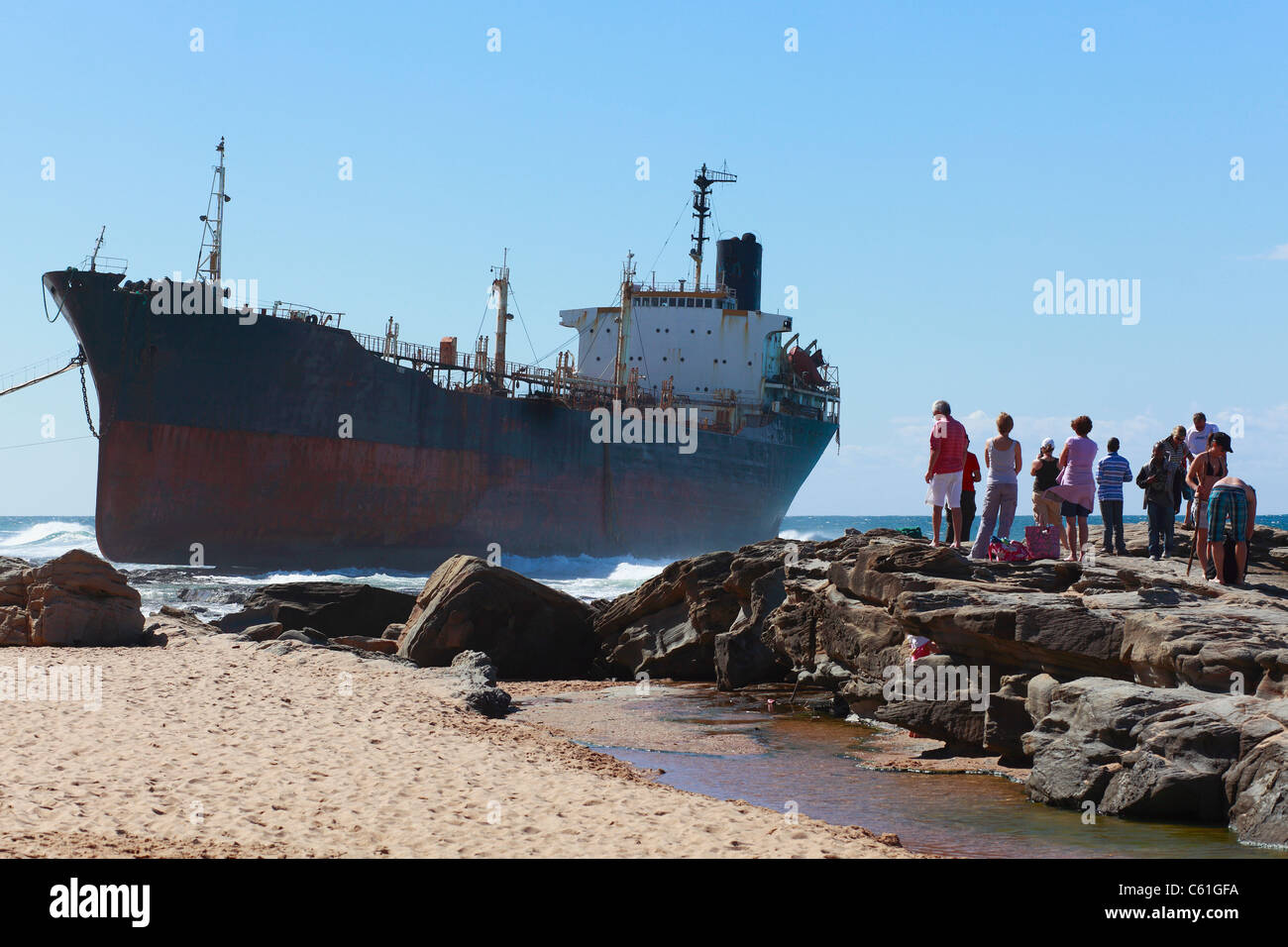 Interessierte Zuschauer blicken auf den Tanker Phoenix, gestrandet auf einem felsigen Regal in Sheffield Beach, KwaZulu Natal, Südafrika. Stockfoto