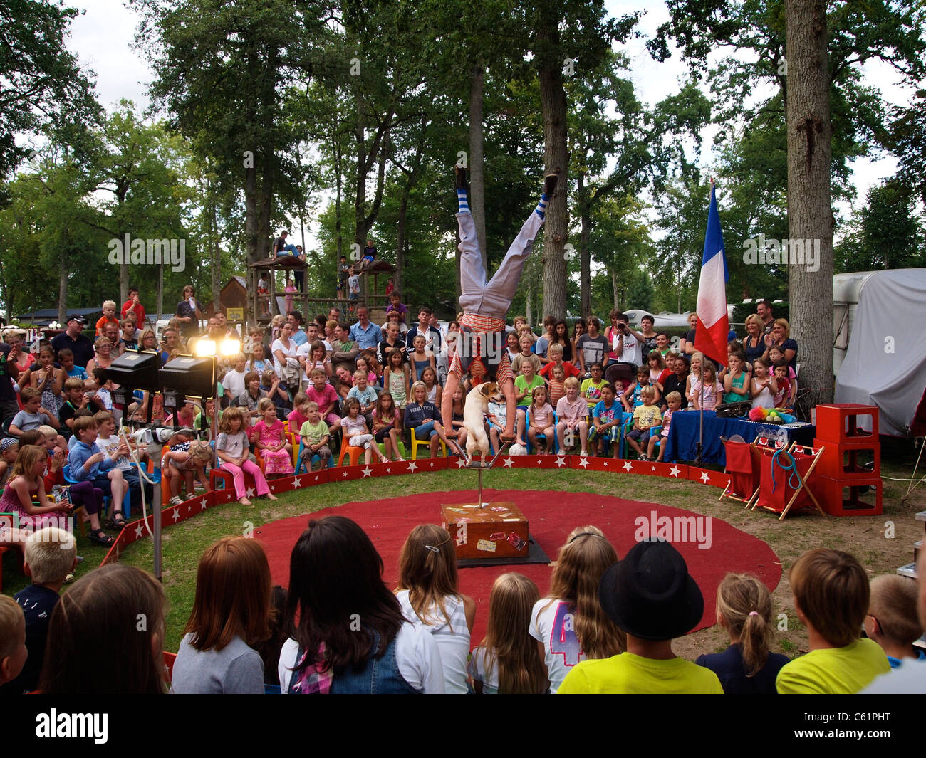 Acrobat mit seinem Hund in einem sehr kleinen Reisen Zirkus steht auf dem Kopf auf einem Campingplatz in der Nähe von Mer, Loiretal, Frankreich Stockfoto