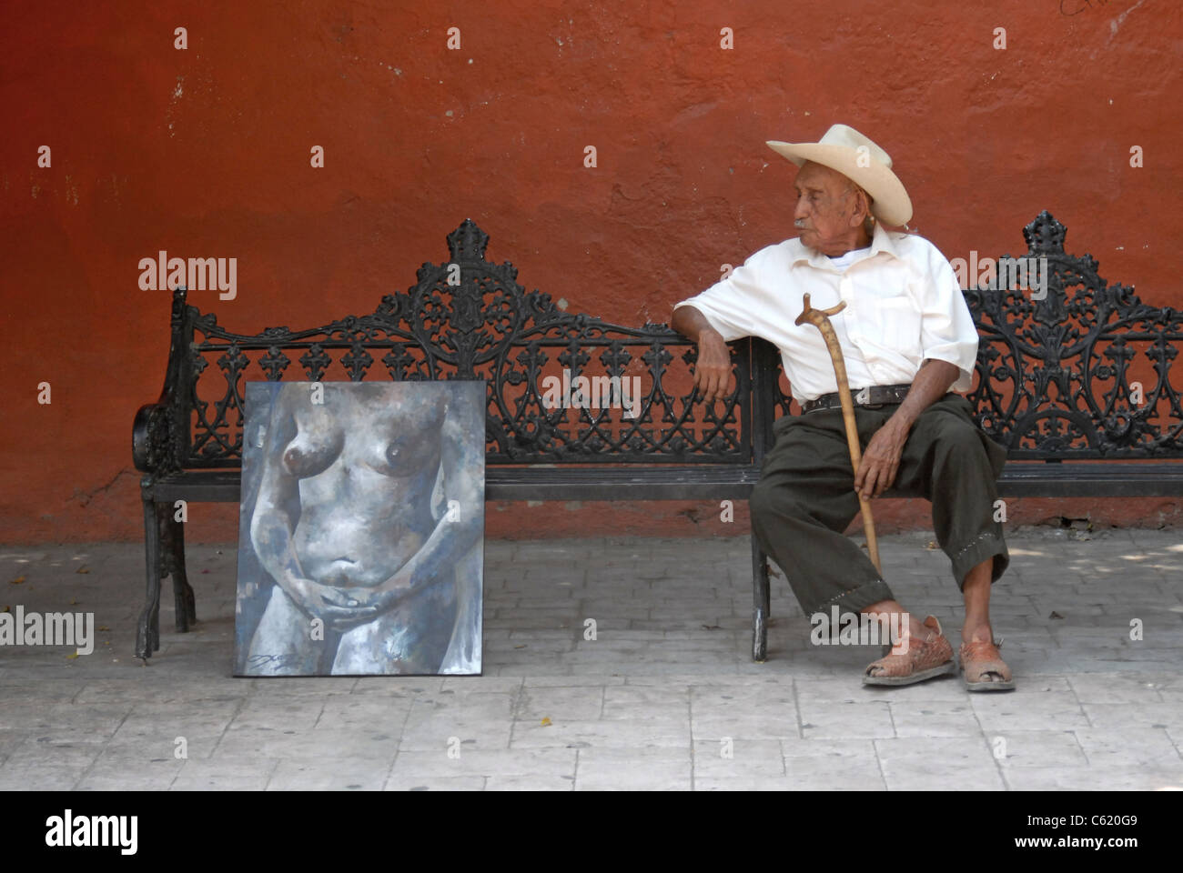 Ein älterer Mann sitzt auf einer Parkbank neben Aktmalerei in diesem Moment spontan eroberten. Stockfoto