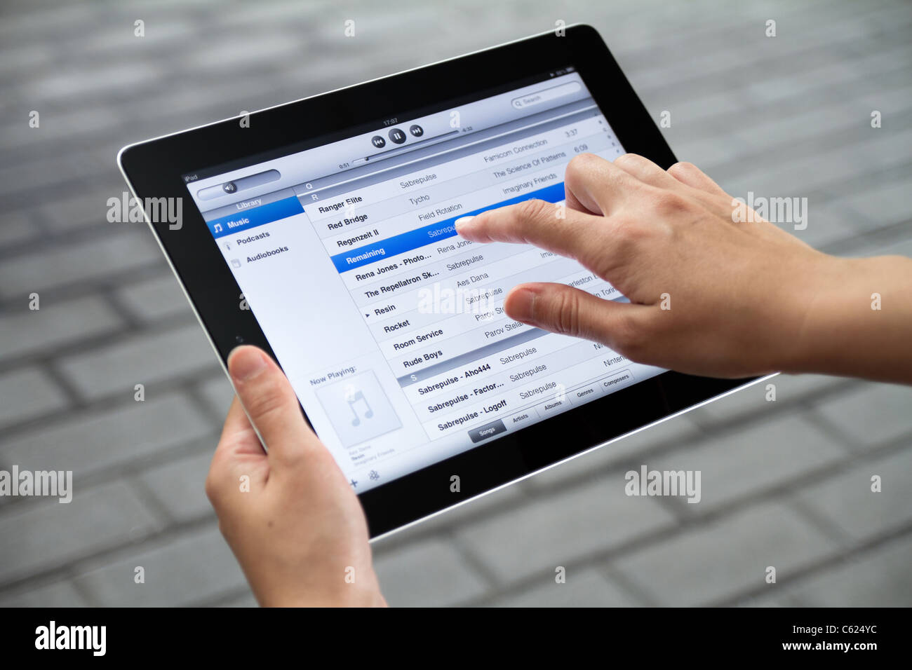 Eine Frau im freien hören Sie Musik auf Apple Ipad2 Stockfoto