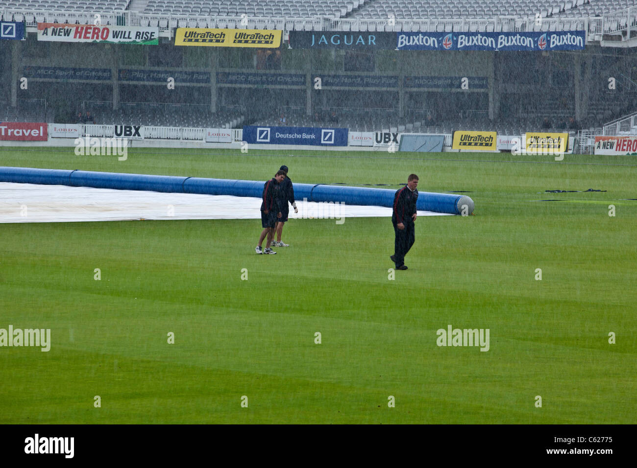 Boden-Personal erhalten getränkt, wie Regen hört auf Lords Cricket Ground spielen Stockfoto