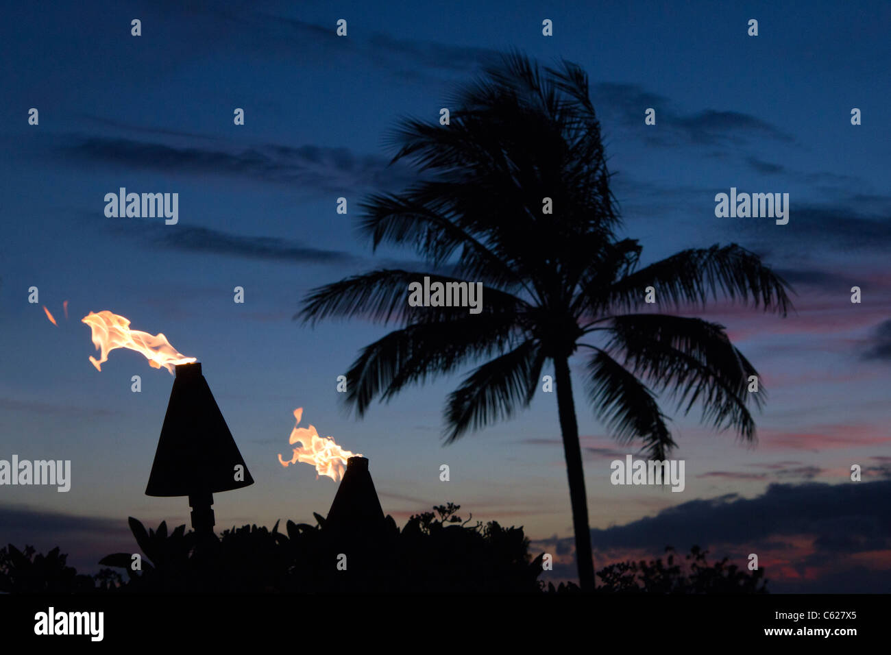 Flammen von Tiki-Fackeln bei Sonnenuntergang auf Hawaii Stockfoto