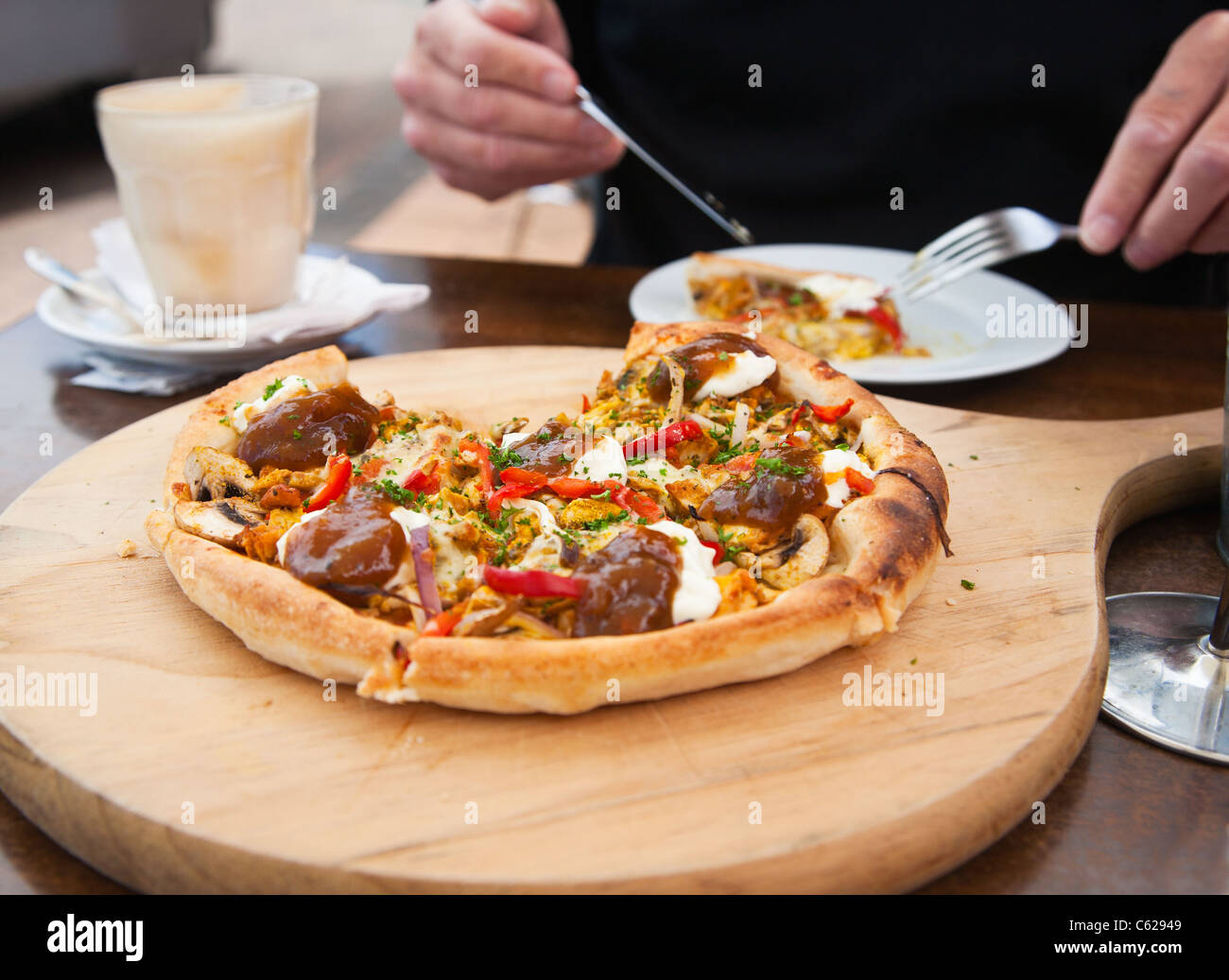 Mann isst ein Stück frisch zubereitete Pizza in einem Café. Stockfoto