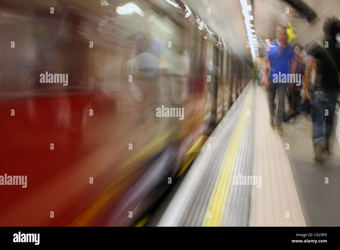 eine Plattform für eine u-Bahnstation mit Passanten und einem fahrenden Zug, während des Gehens mit Kamera in Hüfthöhe getroffen Stockfoto