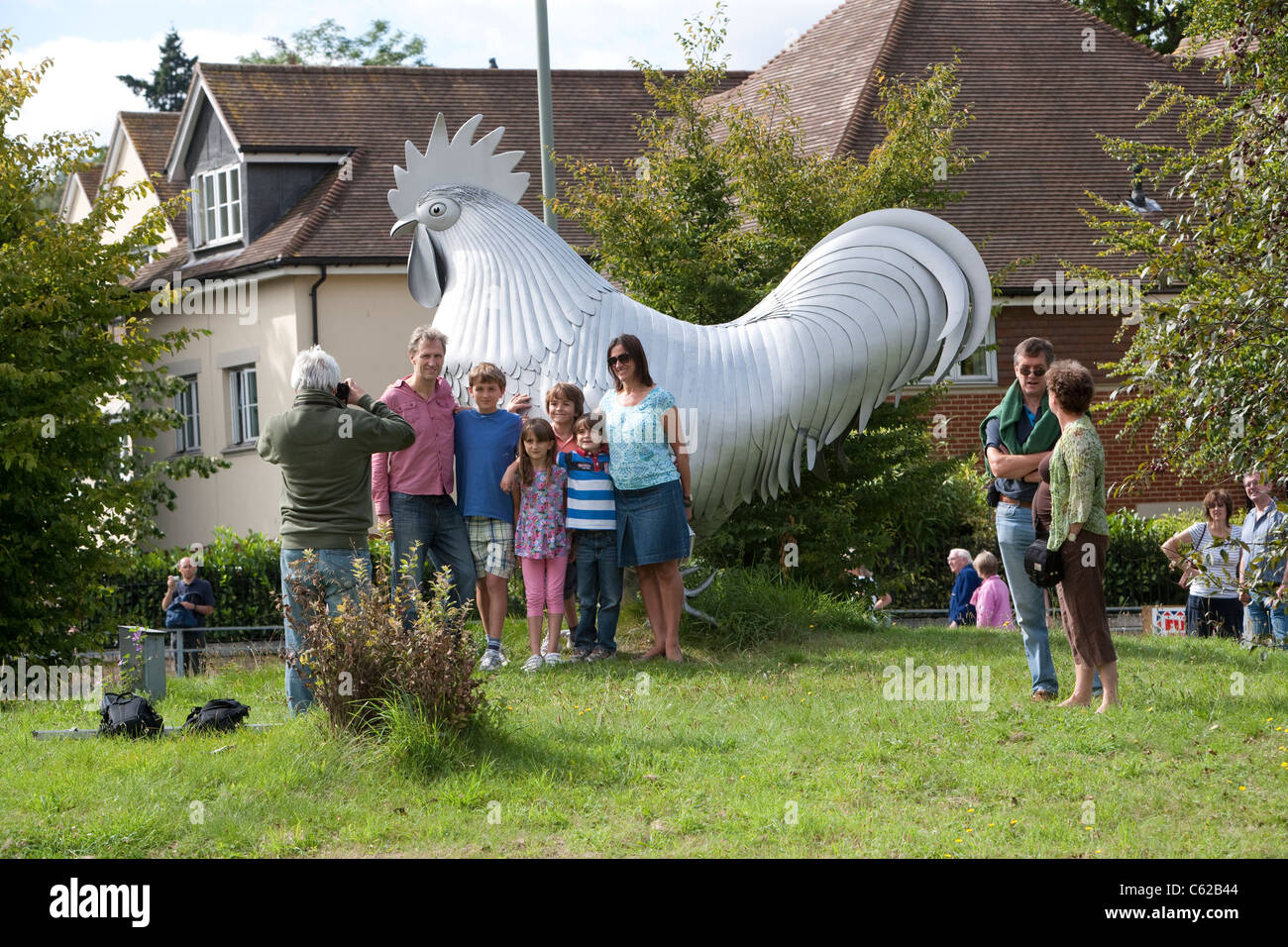 Eine Familie Pose durch die riesigen Dorking Hahn, der schmückt den Kreisverkehr an der Kreuzung der A24 und A25 in Dorking, Surrey Stockfoto