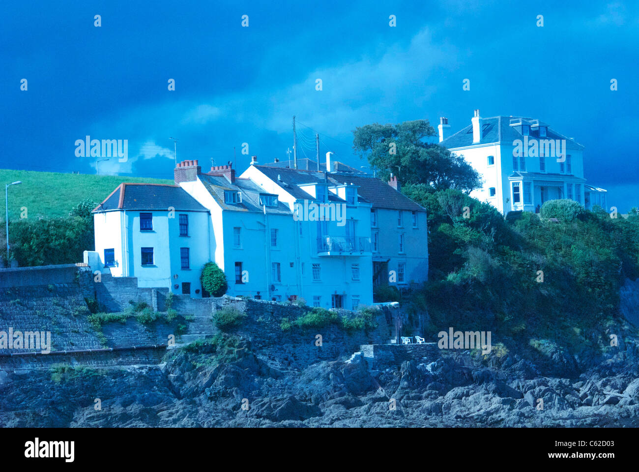 Weiße Häuser auf der Klippe mit Blick auf Meer, die mit Wolfram Licht Einstellung Stockfoto