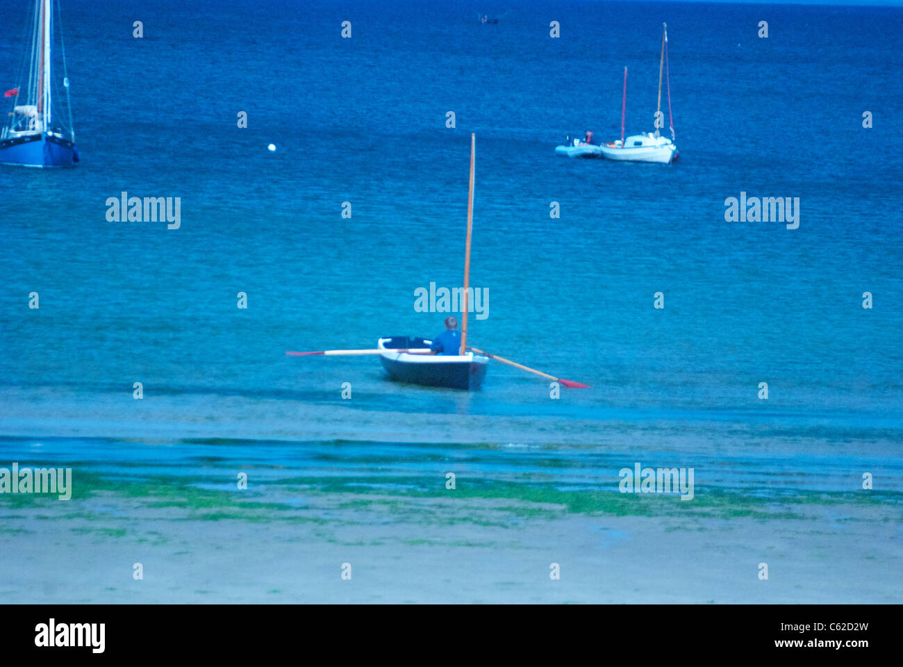 Ruderboot auf blauen ruhiger See nahe dem Strand mit Wolfram Lichteinstellungen aufgenommen Stockfoto