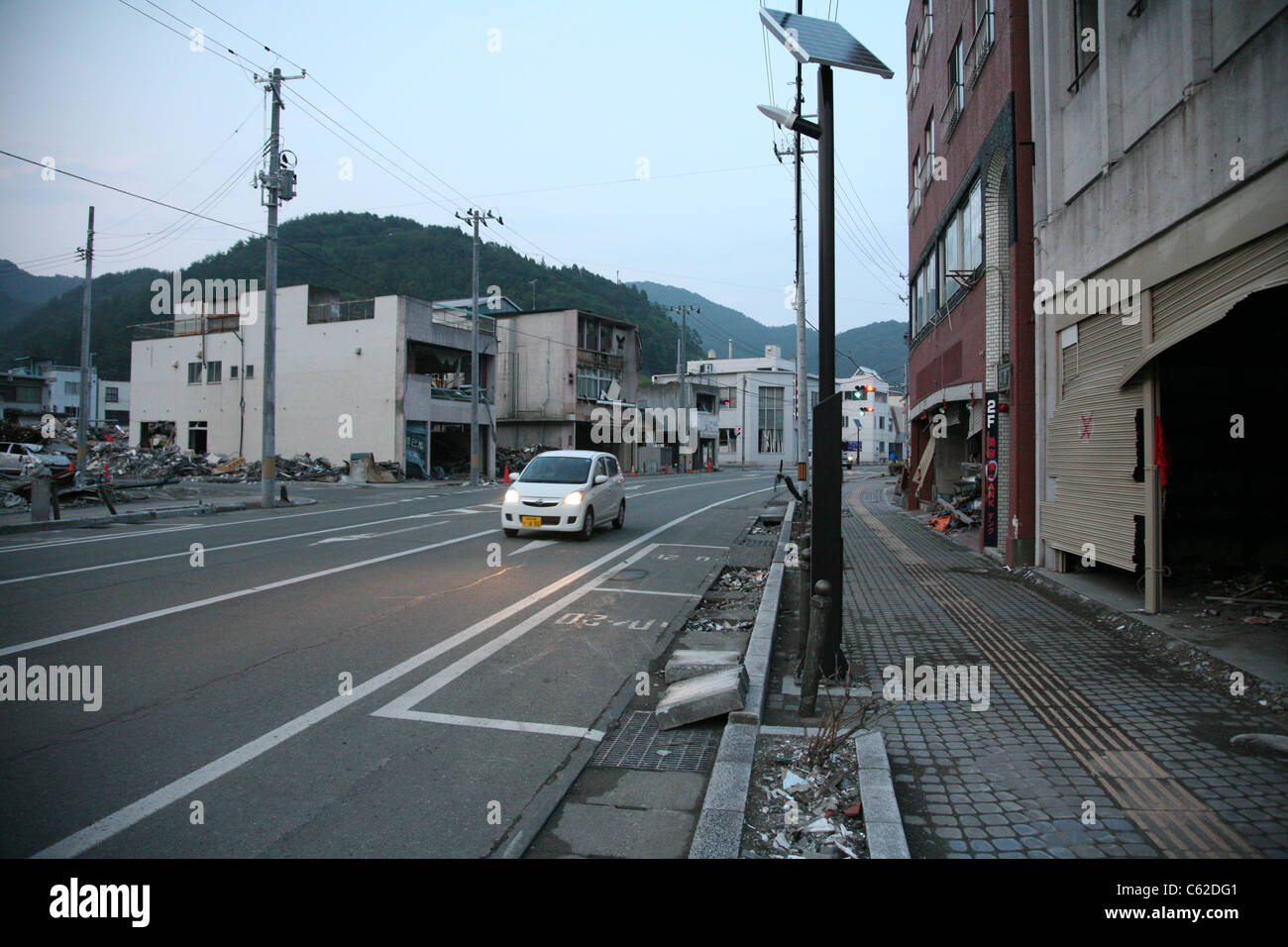 Ein Auto fährt nach unten durch zerstörte Gebäude in Kamaishi, Japan, Juni 2011 Stockfoto