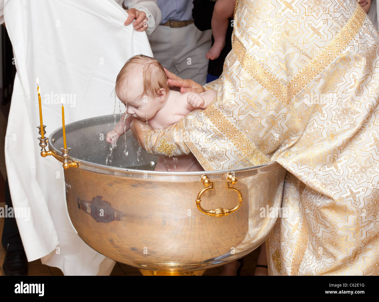 Das Taufessen Und Andere Szenen Baby-Taufe in der russisch orthodoxen Kirche. Priester, die das kleine