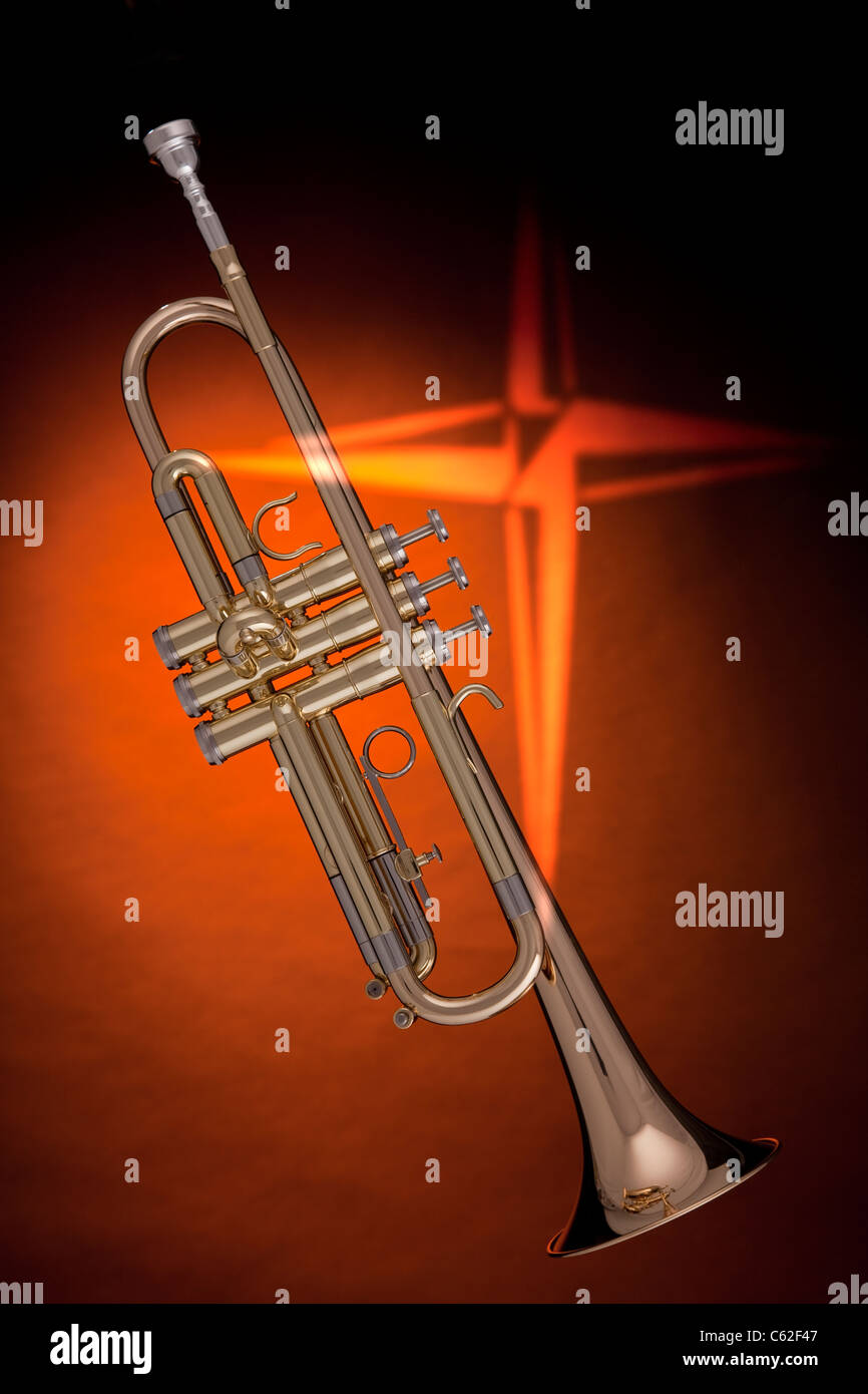 Eine goldene Trompete oder Kornett mit einem Kreuz gegen einen orange Hintergrund im vertikalen Format. Stockfoto