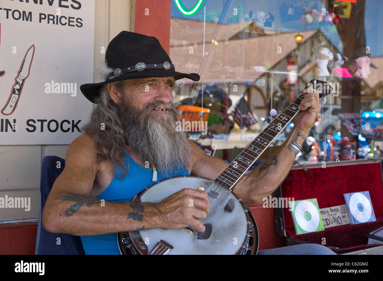Ein lokaler Black Hills Straßenmusiker spielt Banjo und sammelt Spenden in Hill City, South Dakota, USA Stockfoto