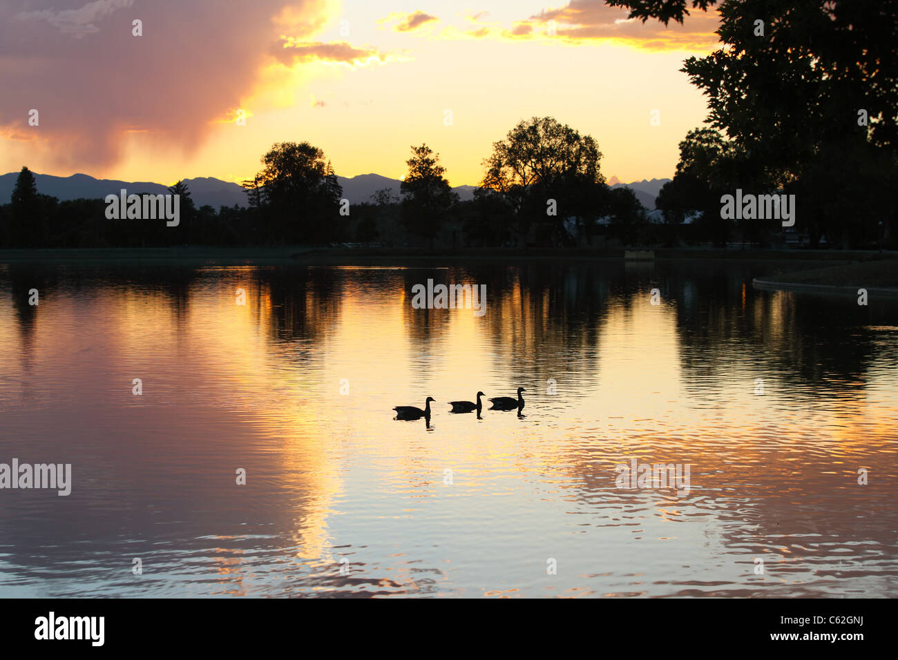 Ein Blick auf die untergehende Sonne über Denver, Colorado. Bild aufgenommen am Stadtpark über Ferril See Stockfoto