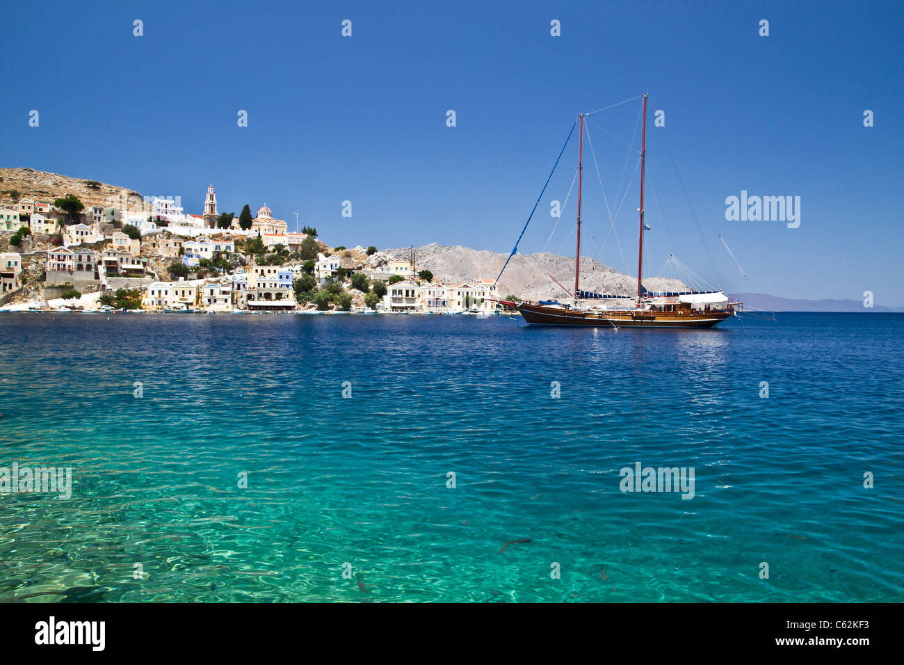 Bunte Häuser und Segelboot in Symi Insel Griechenlands Stockfoto