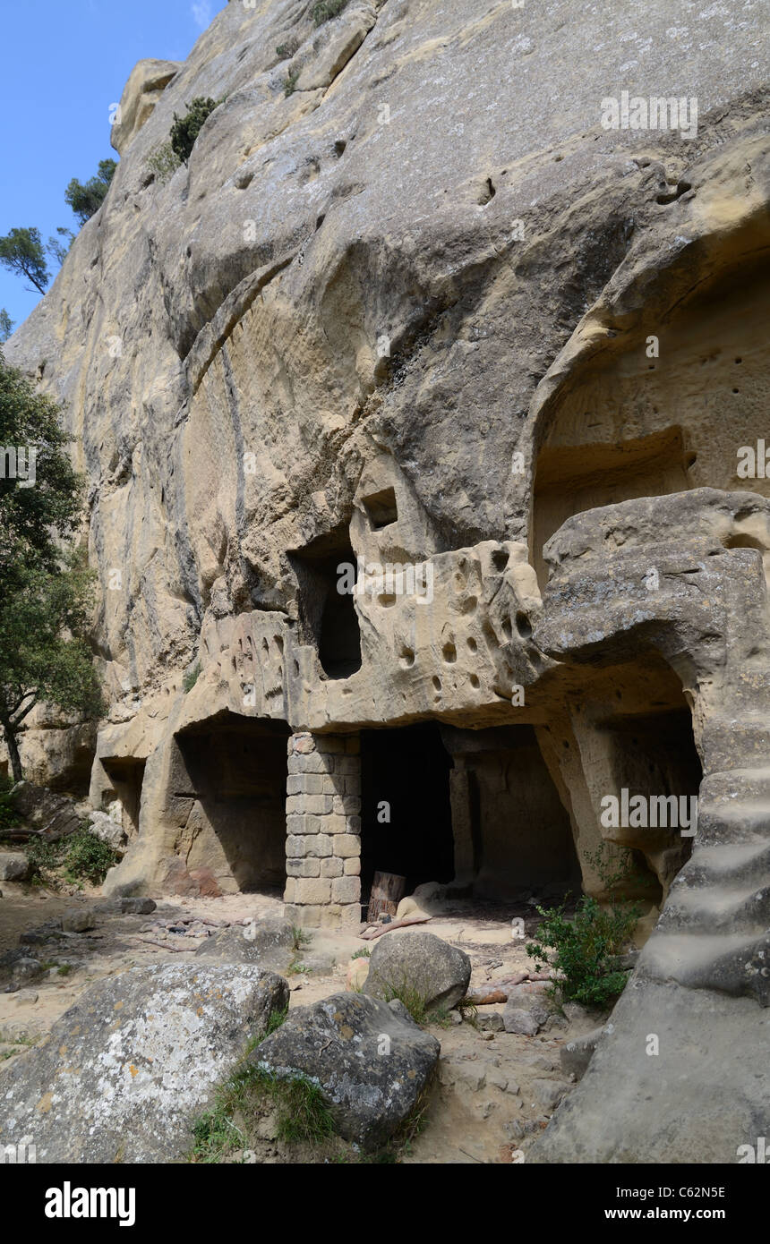 Höhlenhäuser oder Höhlenwohnungen, die aus der Felswand bei den Grottes de Calès, Lamanon, Provence, Frankreich geschnitten wurden Stockfoto