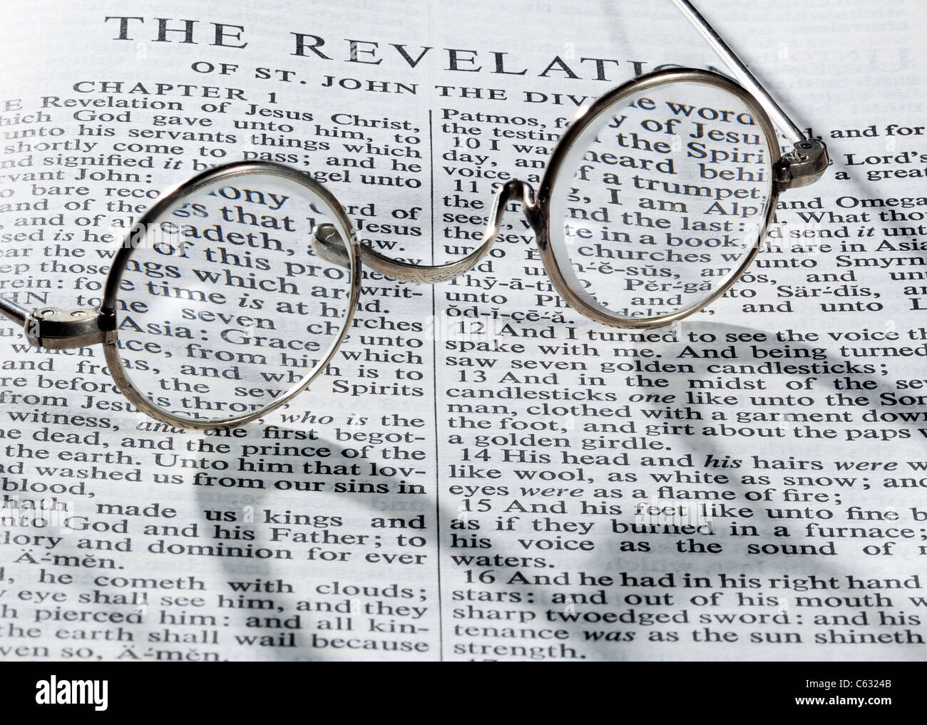 Old fashioned Lesebrille auf einer Seite aus der Bibel im Buch der Offenbarung zu öffnen Stockfoto