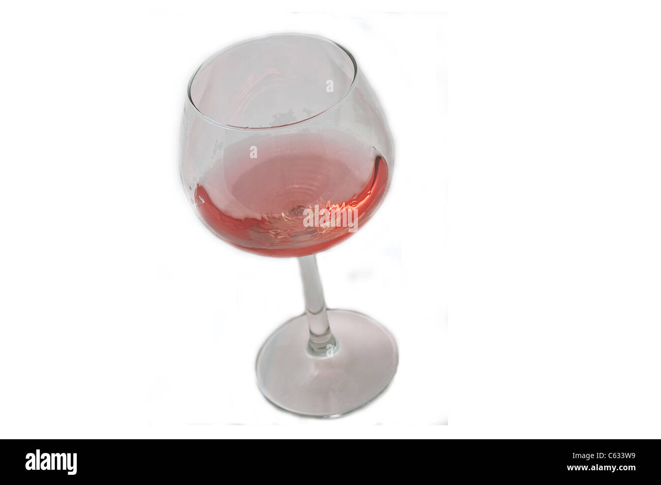 Dieses einzelne lange stemmed Glas hat Blush Wein in einer Diagonale Komposition, isoliert auf einem weißen Hintergrund. Stockfoto