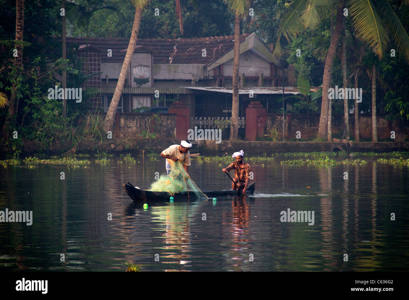 Zwei Fischer in Netzen in den frühen Morgenstunden ziehen Licht Backwaters Kerala Süd-Indien Stockfoto