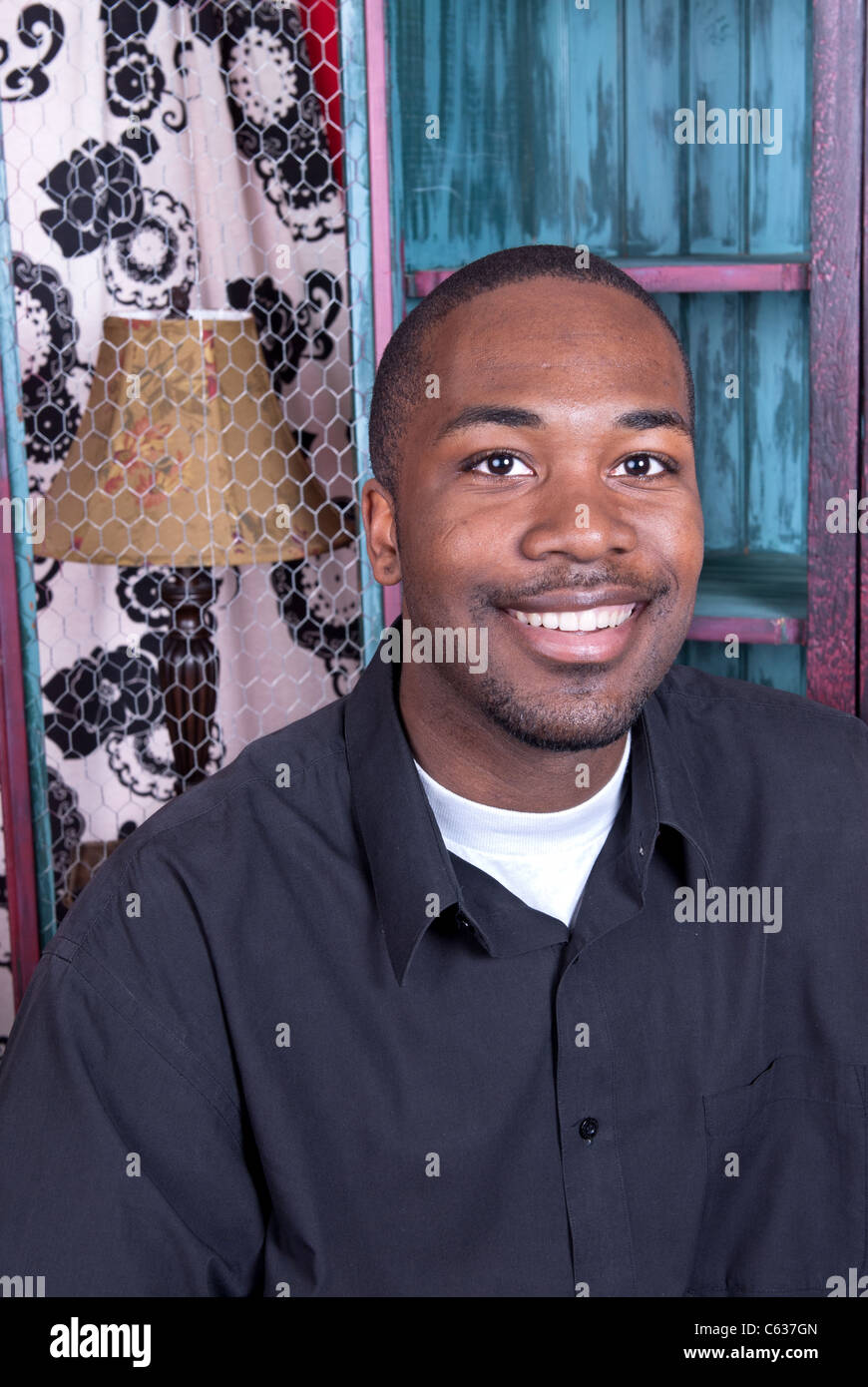Ein schwarzer Mann lächelnd während in seinem Büro zu Hause. Stockfoto