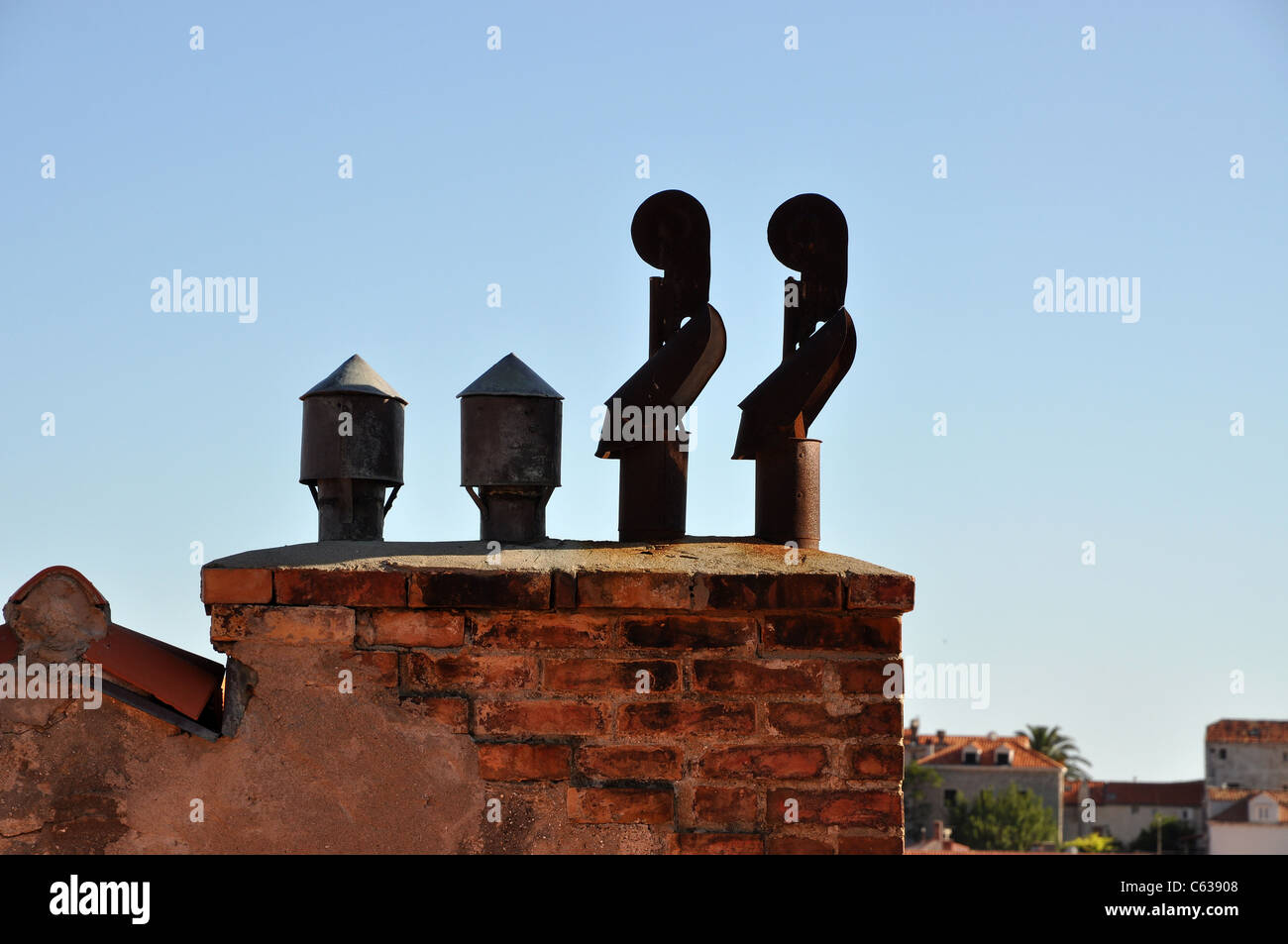 Vier Auspuffrohre auf einem gemauerten Schornstein Stockfoto