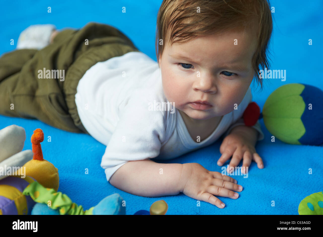 Kleines Mädchen auf blaue Decke Gras außen liegend Stockfoto