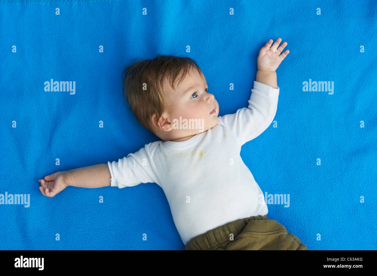 Kleines Mädchen auf blaue Decke Gras außen liegend Stockfoto