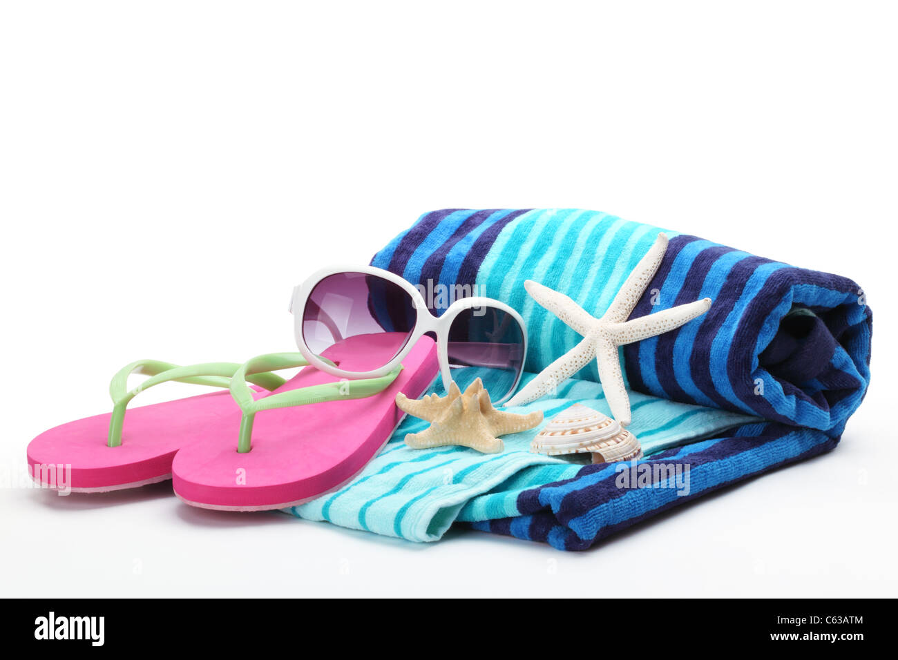 Strand-Accessoires mit Flip-Flops, Handtuch und Sonnenbrille auf weißem Hintergrund. Stockfoto