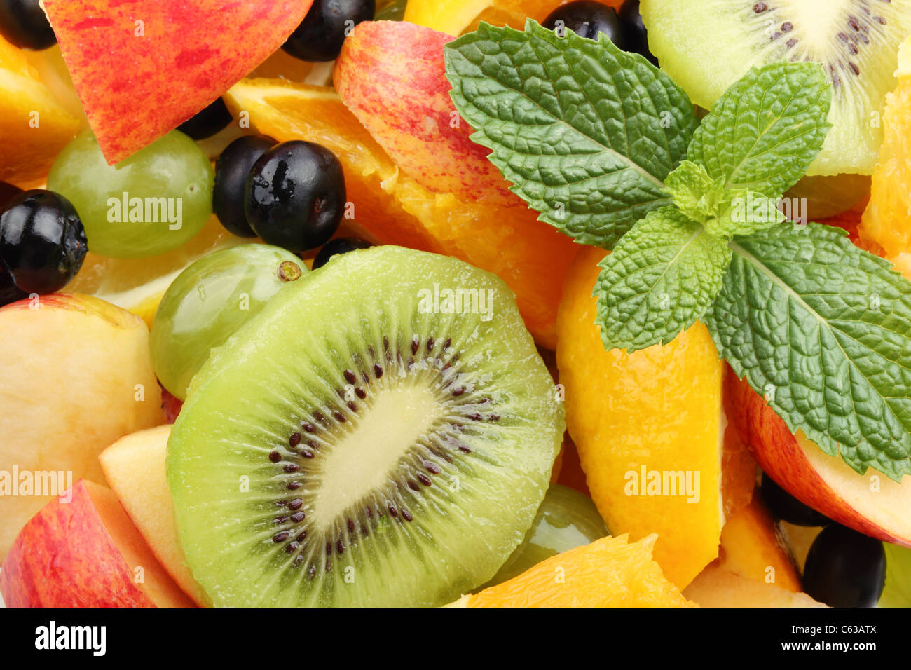 Frischer Obstsalat mit Kiwi, Blaubeeren, Orangen, Weintrauben und Minze. Stockfoto