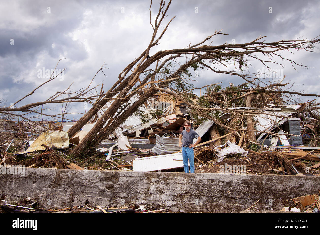 Ein Mann steht vor einem Haus, das er nach einem Tornado in Joplin, Missouri, 25. Mai 2011 von gecrawlt. Stockfoto