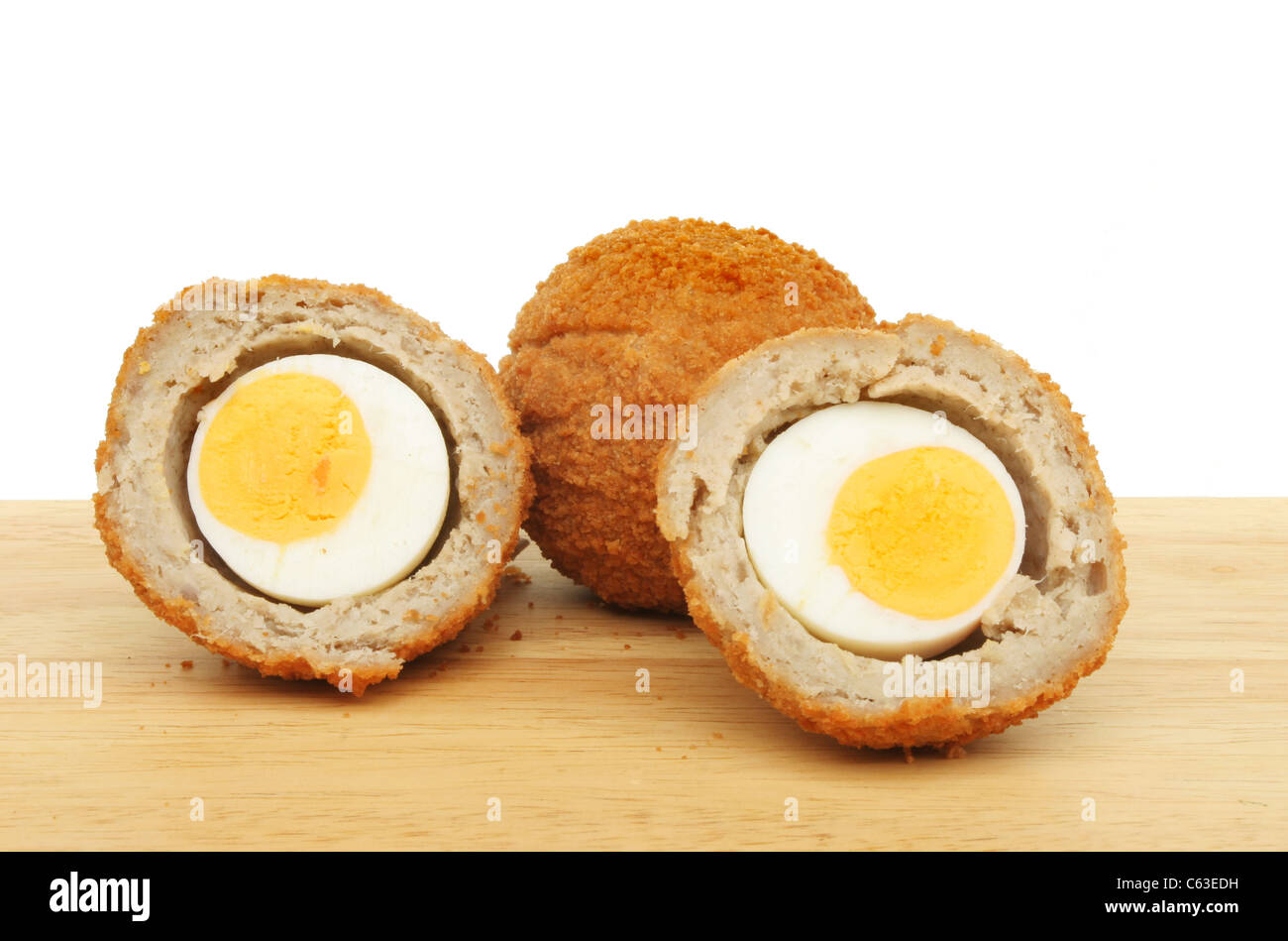 Ganze und geschnittene Scotch Eiern auf einem Brett aus Holz Essen Vorbereitung Stockfoto