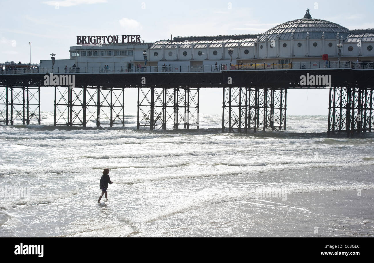 Brighton Pier mit Menschen spielen in den Wellen Stockfoto