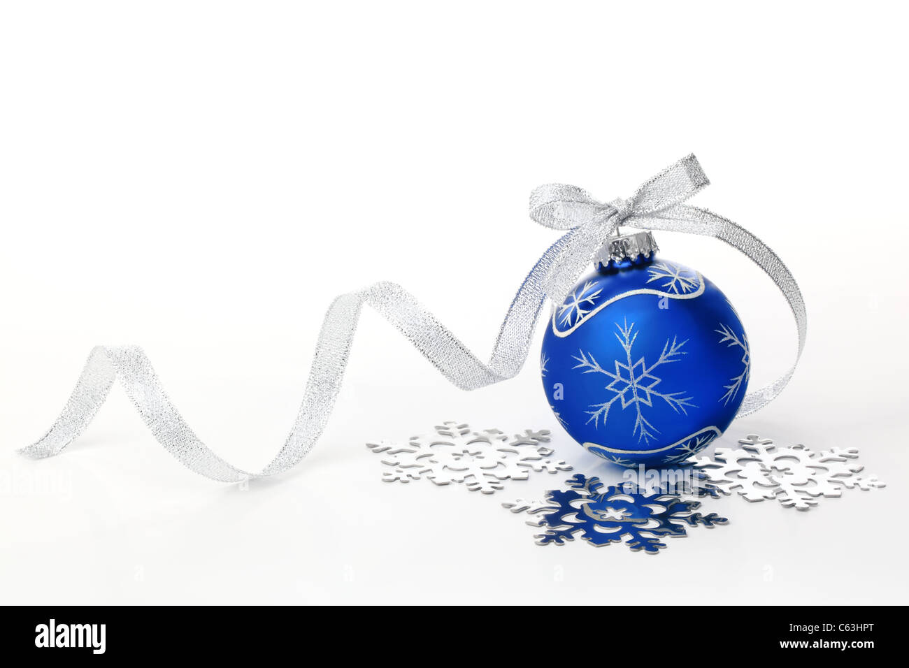 Blaue Weihnachtskugel mit silbernen Schleife und Schneeflocke auf weißem Hintergrund. Stockfoto