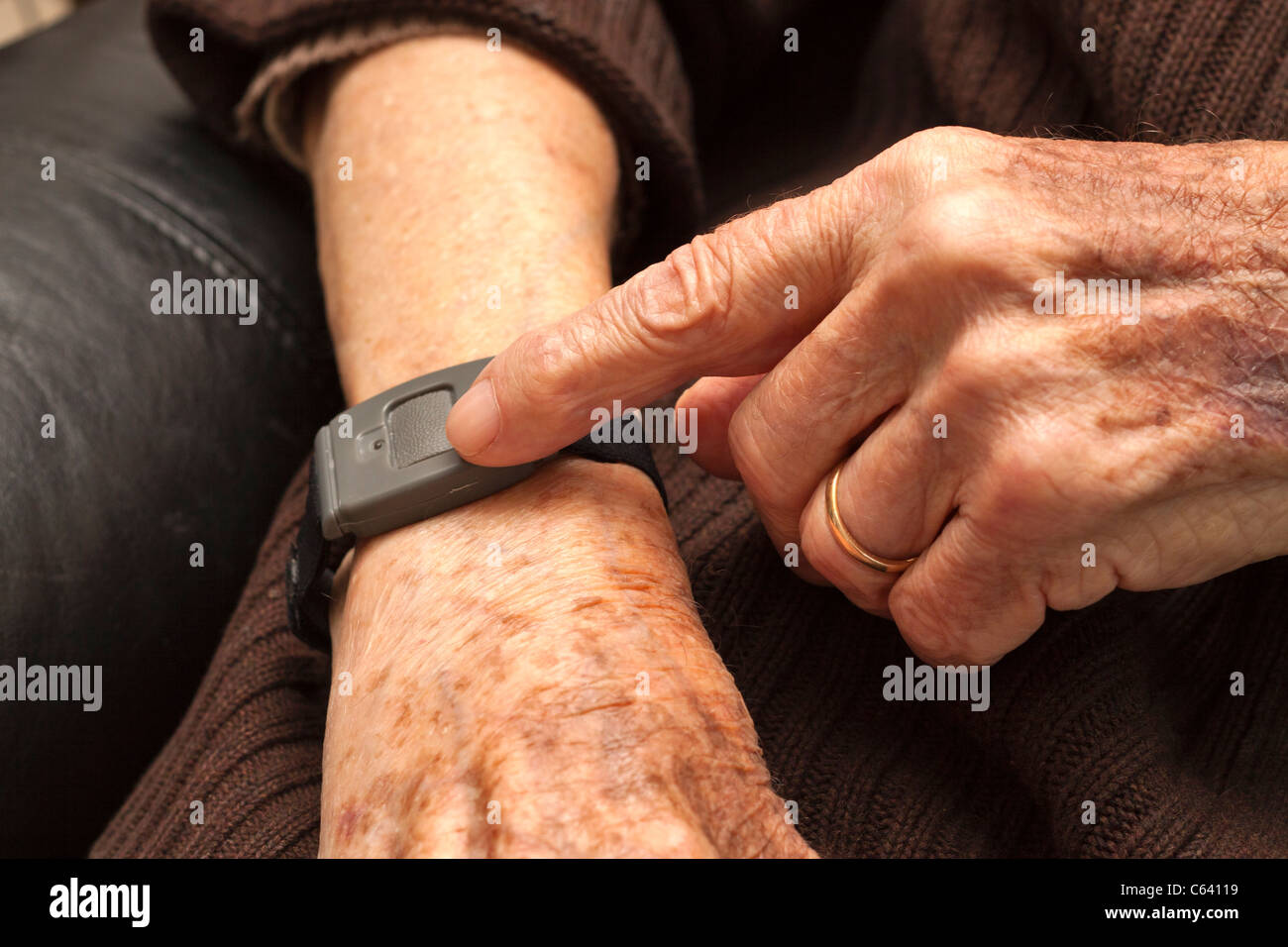 Senioren mit einer medizinischen Alarm alarm-System auf ein Armband. Stockfoto