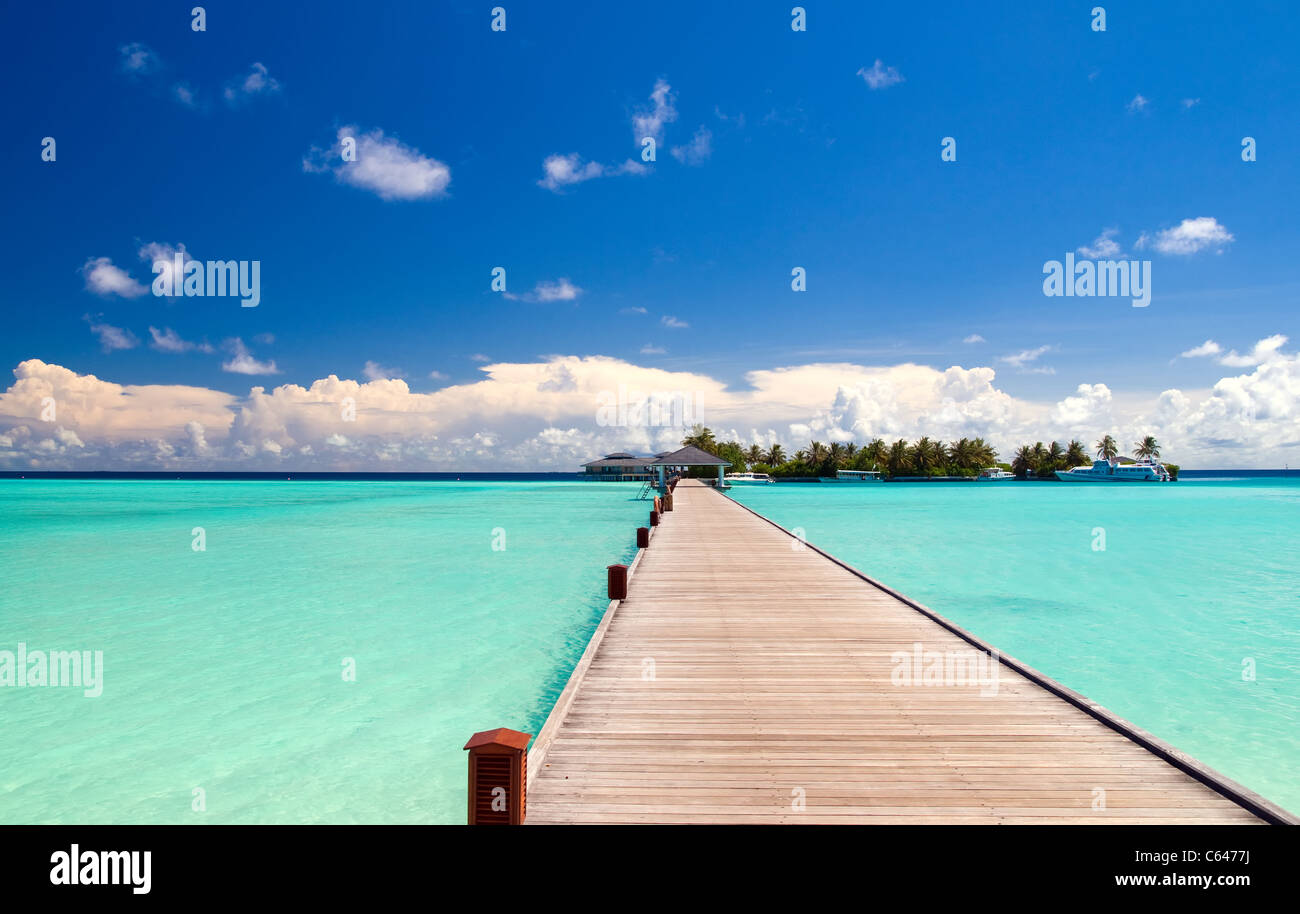 Fußgängerbrücke über türkisblaue Meer auf einer maledivischen Insel Stockfoto