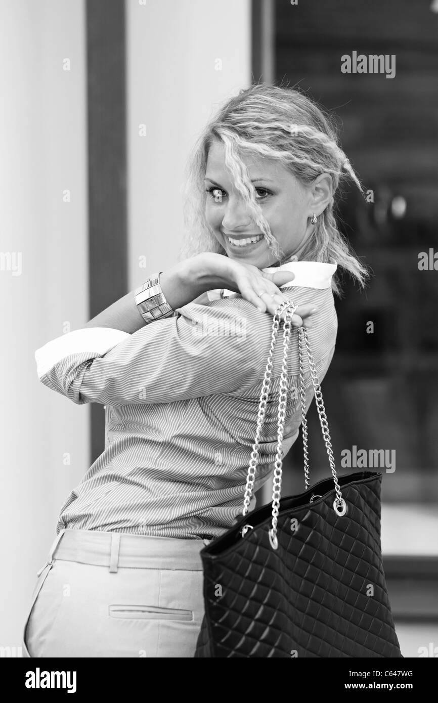 glücklich blonde Frau mit schwarze Tasche. Stockfoto