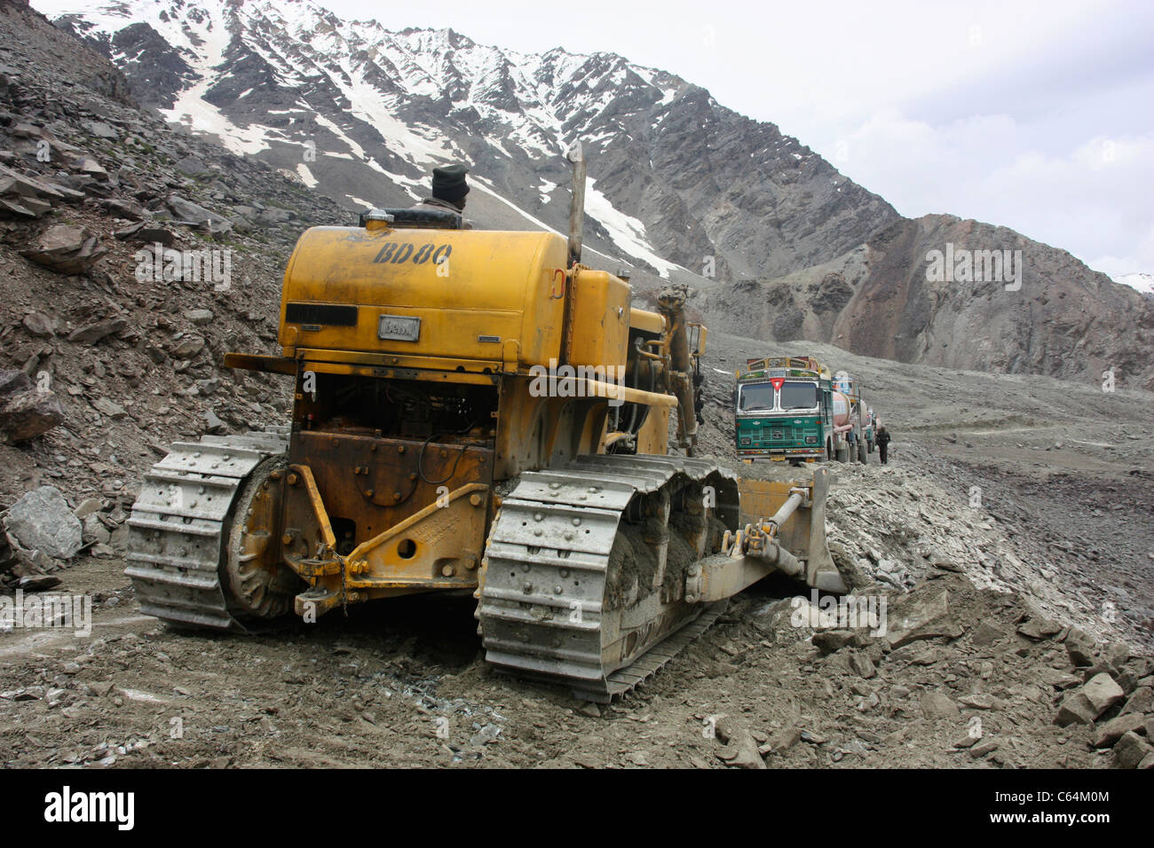 Planierraupe löscht Route durch einen Erdrutsch als Konvoi aus Lastwagen warten in der Nähe auf dem tückischen Himalaya Weg nach Leh Ladakh Stockfoto