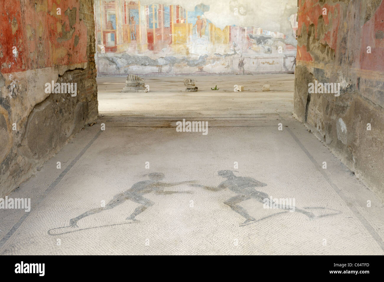 Eingang eines Hauses, das auf einem Gymnasium, Pompeji umgewandelt wurde. Ein Bodenmosaik zeigt zwei Athleten und die Wände zeigen Fresken. Stockfoto