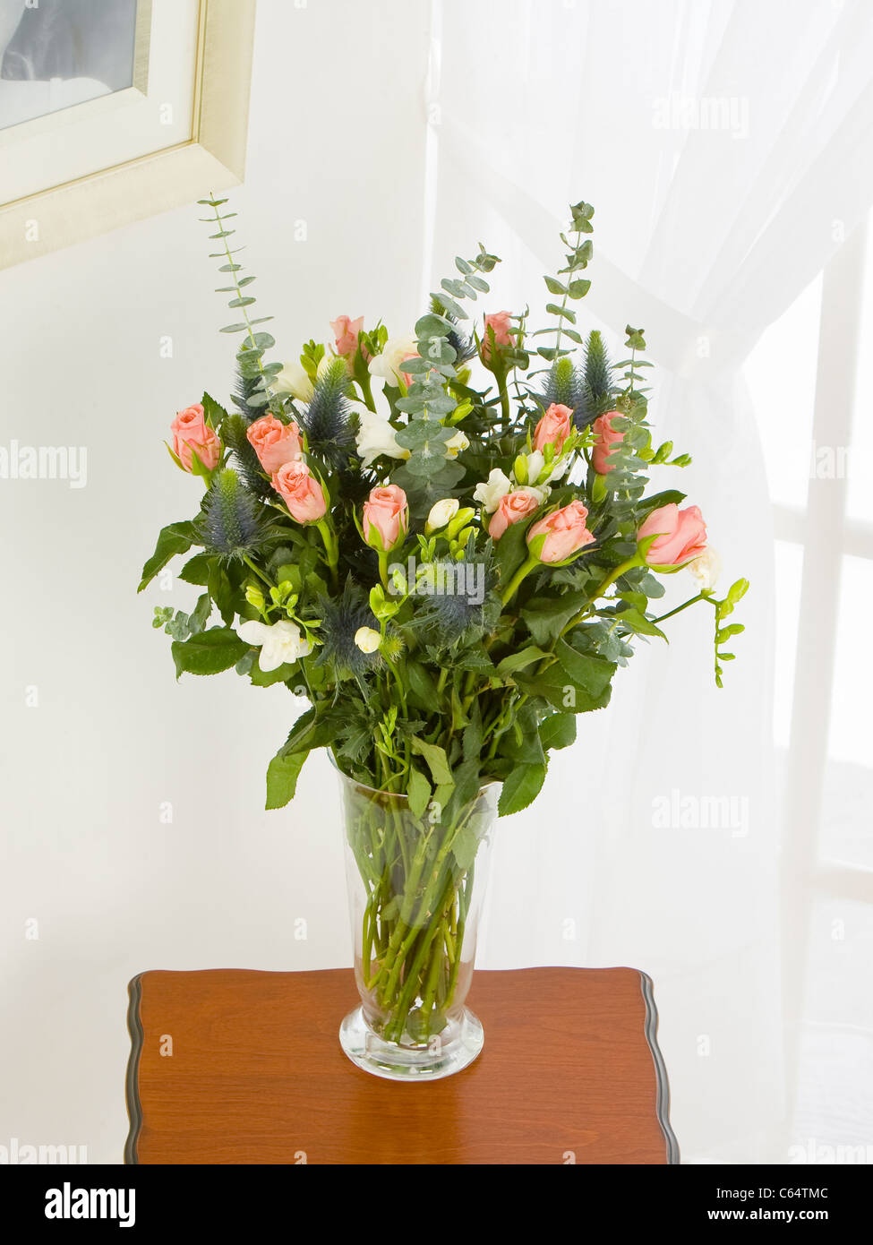 Ein gemischter Blumenstrauß orange Rosen und weißen Freesien Stockfoto