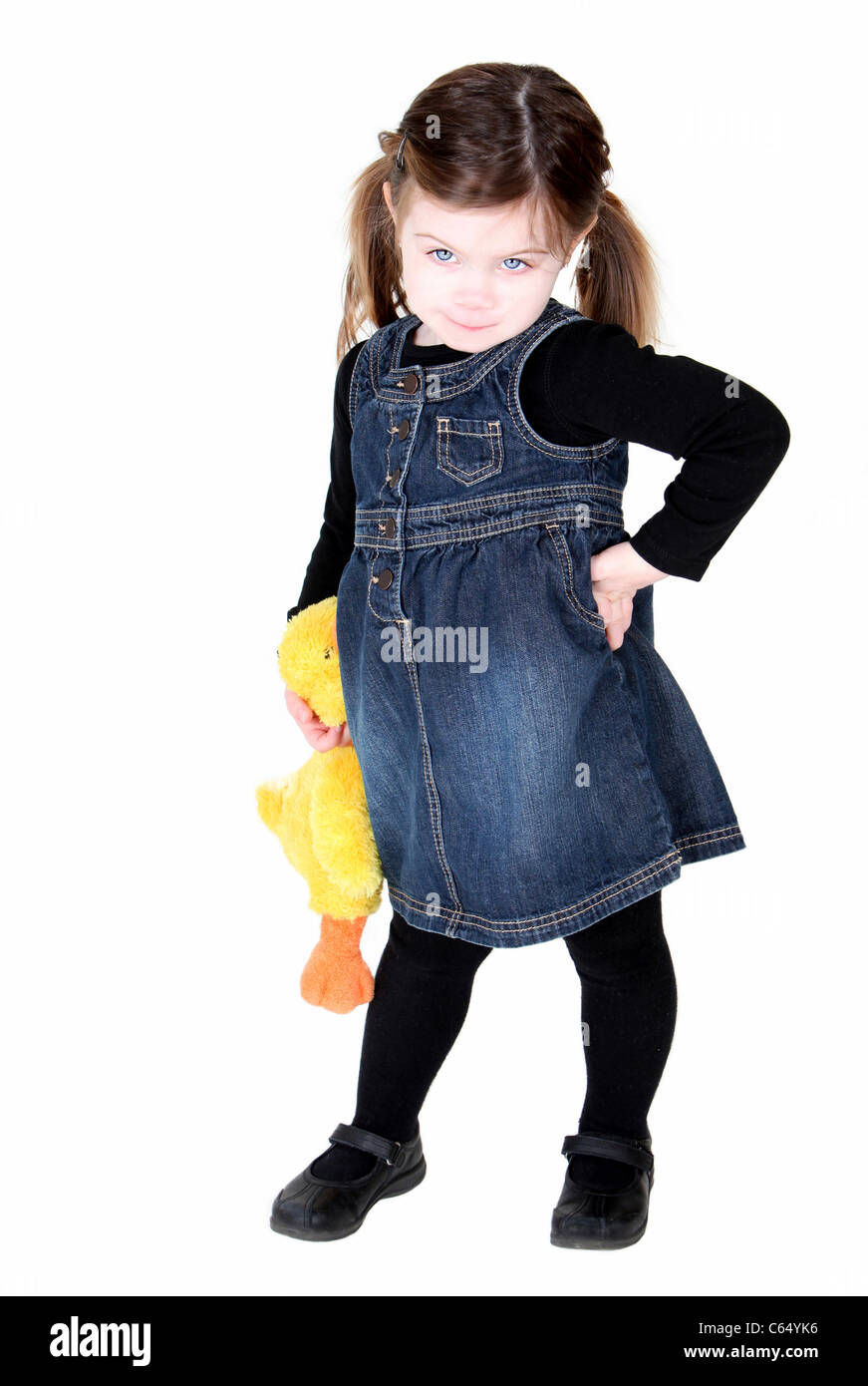 Hübsches Kleinkind Mädchen mit Hand auf Hüften und ausgestopfte Tiere, Haltung zeigen Stockfoto