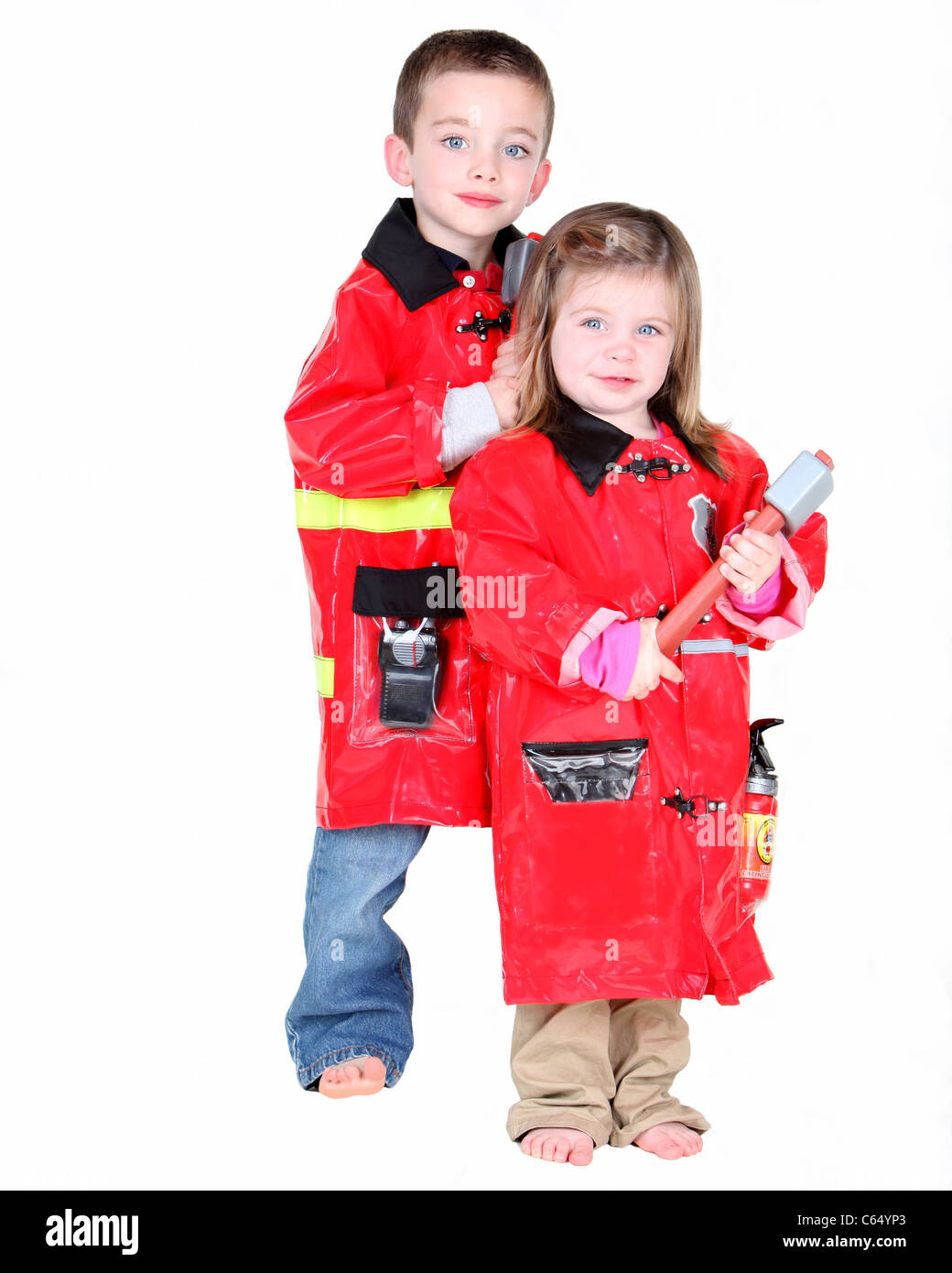 Zwei junge Kinder, verkleidet als Feuerwehrmänner auf weißem Hintergrund Stockfoto